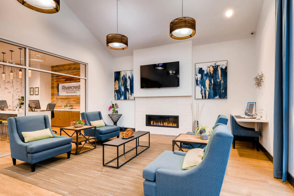 Clubhouse lounge with armchairs around a fireplace