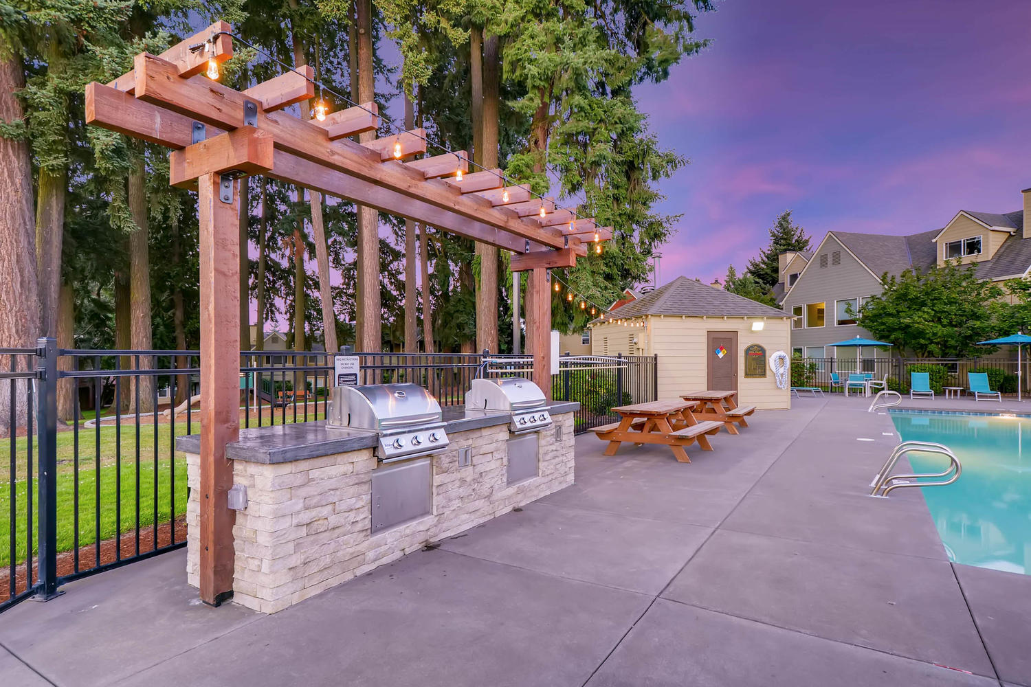 Outdoor grills and picnic tables by the pool