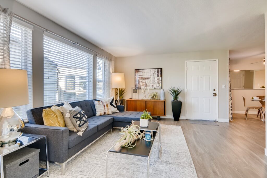 Open living room with large windows and view of dining and kitchen