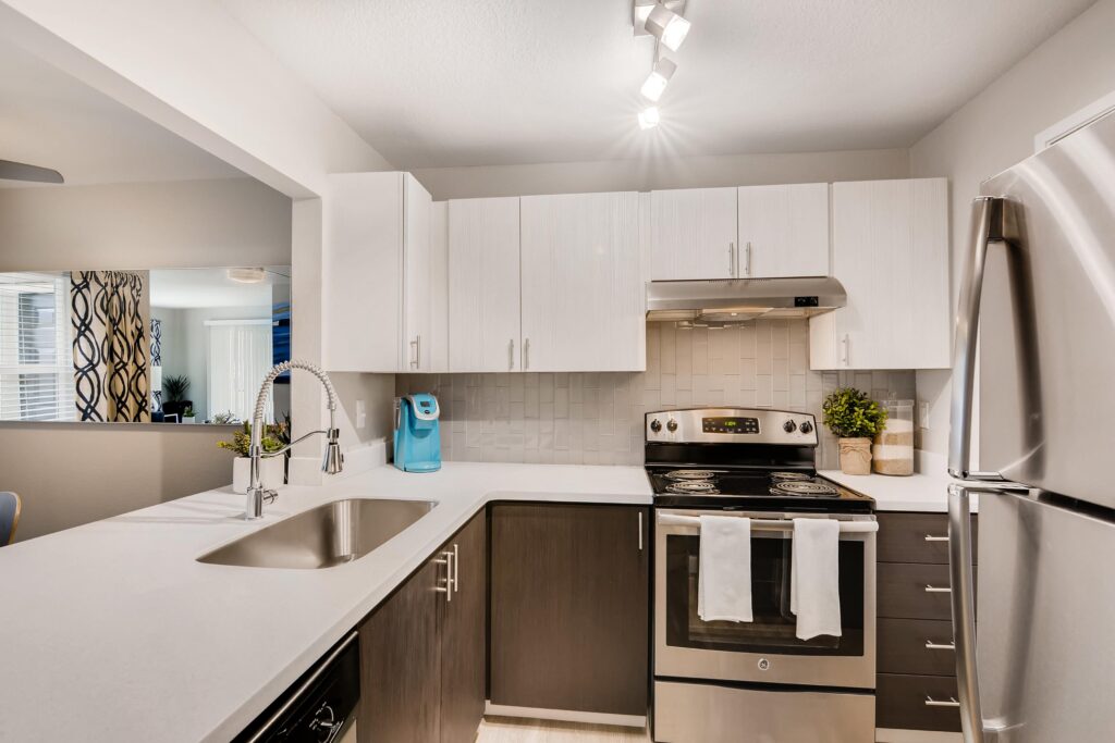 Kitchen with white counters, stainless steel appliances, and washer dryer closet