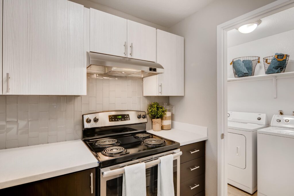 Kitchen with white counters, stainless steel appliances, and washer dryer closet