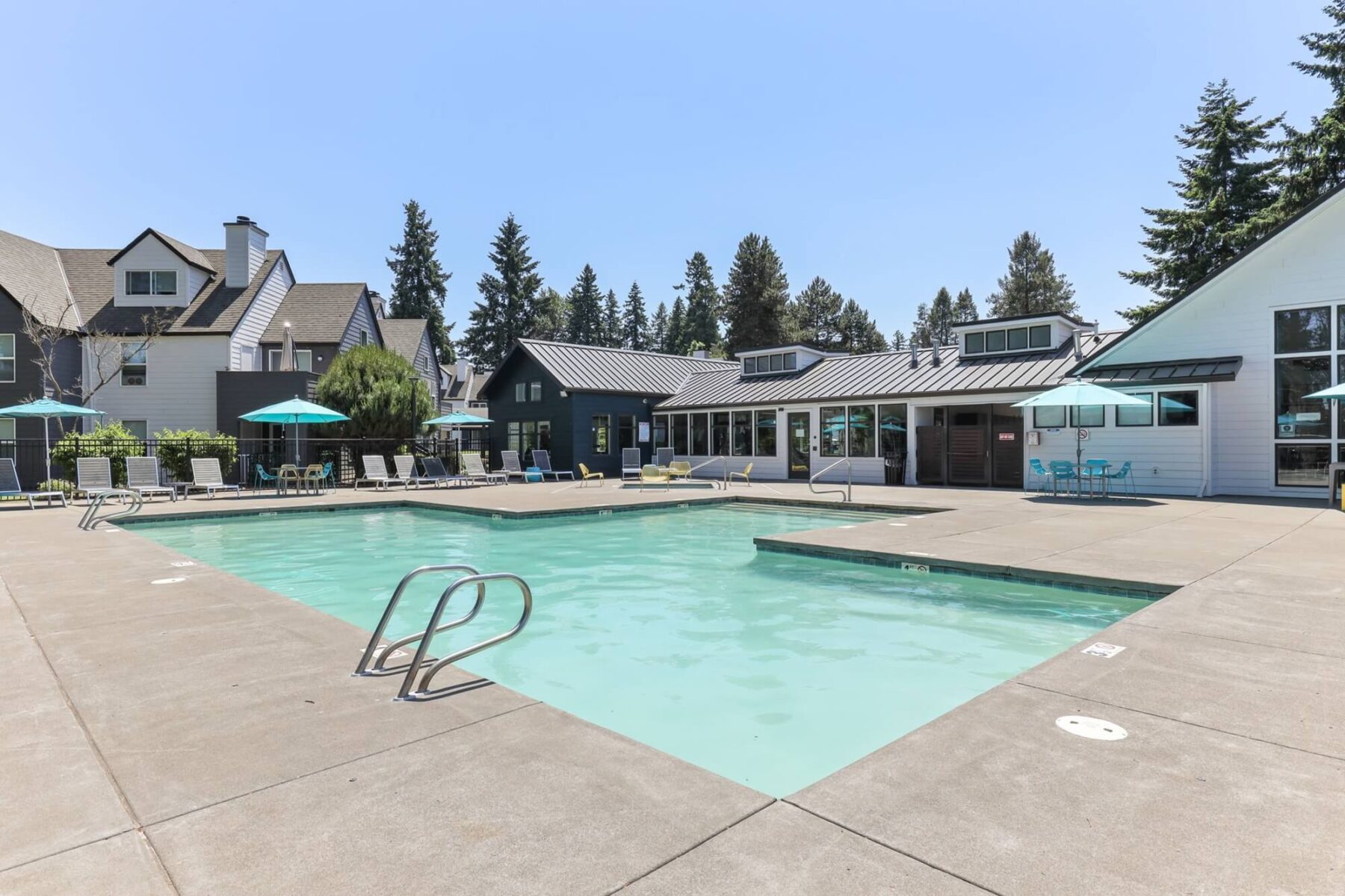 swimming pool with patio seating and umbrellas