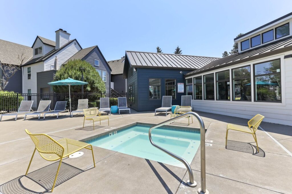 hot tub with patio chairs and lounge seating